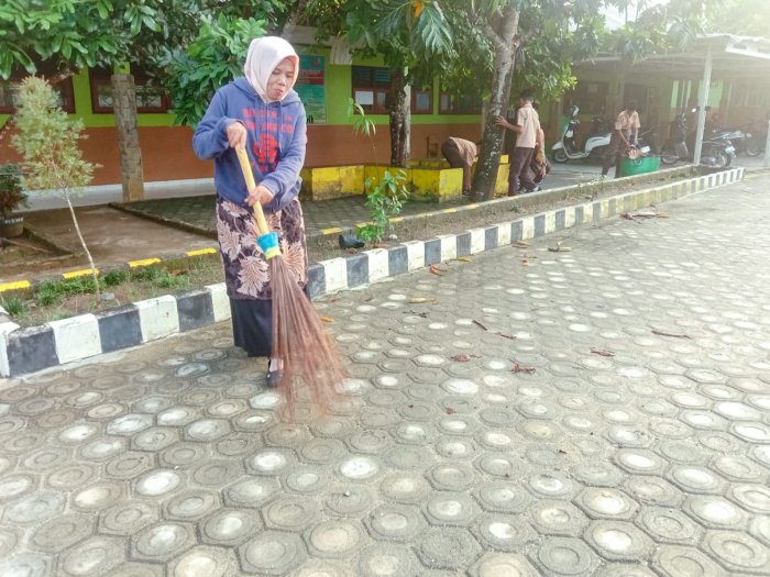 Dedikasi Tanpa Batas, Guru Piket MTsN 1 Bungo Ikut Bersihkan Lingkungan Madrasah