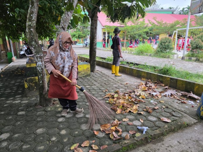 Aksi Nyata Deswanti, S.Ag Guru Piket MTsN 1 Bungo Turun Langsung Bersihkan Lingkungan Sekolah