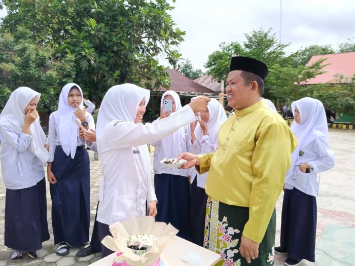 Momen Haru OSIM Berikan Suapan Kue kepada Kepala Madrasah di Hari Guru Nasional